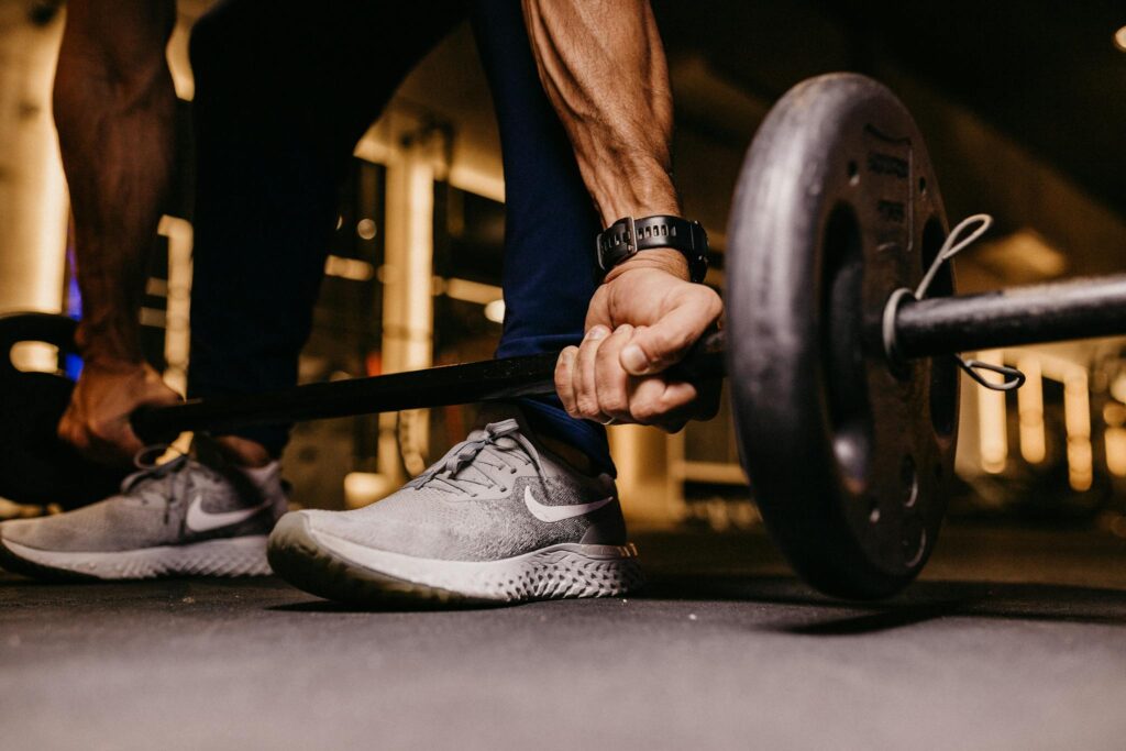 Focused image of a man lifting weights indoors, capturing strength and determination.